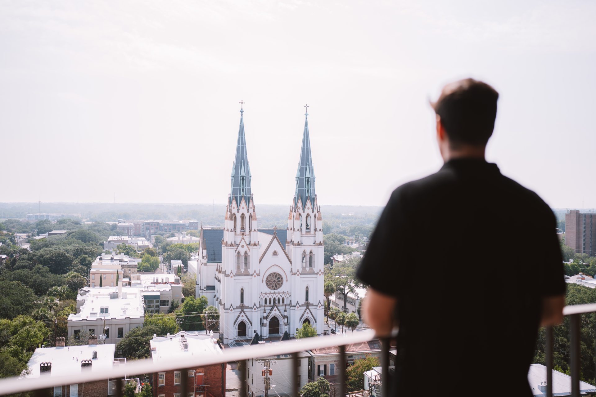 man staring at church from balcony
